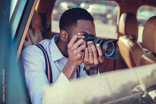 A blackman shooting on dslr from the car. photo