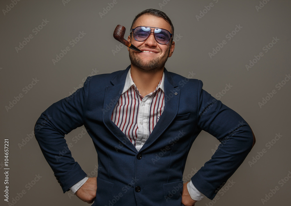 A man in sunglasses and in a suit smoking pipe. A man in sunglasses and in a suit smoking pipe.