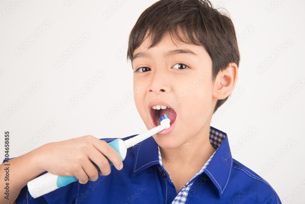 © wckiw - Little boy using electric toothbrushes on white background