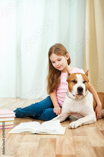 Little girl with staffordshire terrier dog