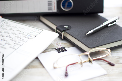 Office workplace with laptop, folders and agenda on wood table