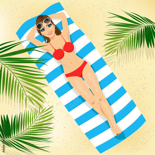 top view of woman with sunglasses in bikini lying on colorful beach towel