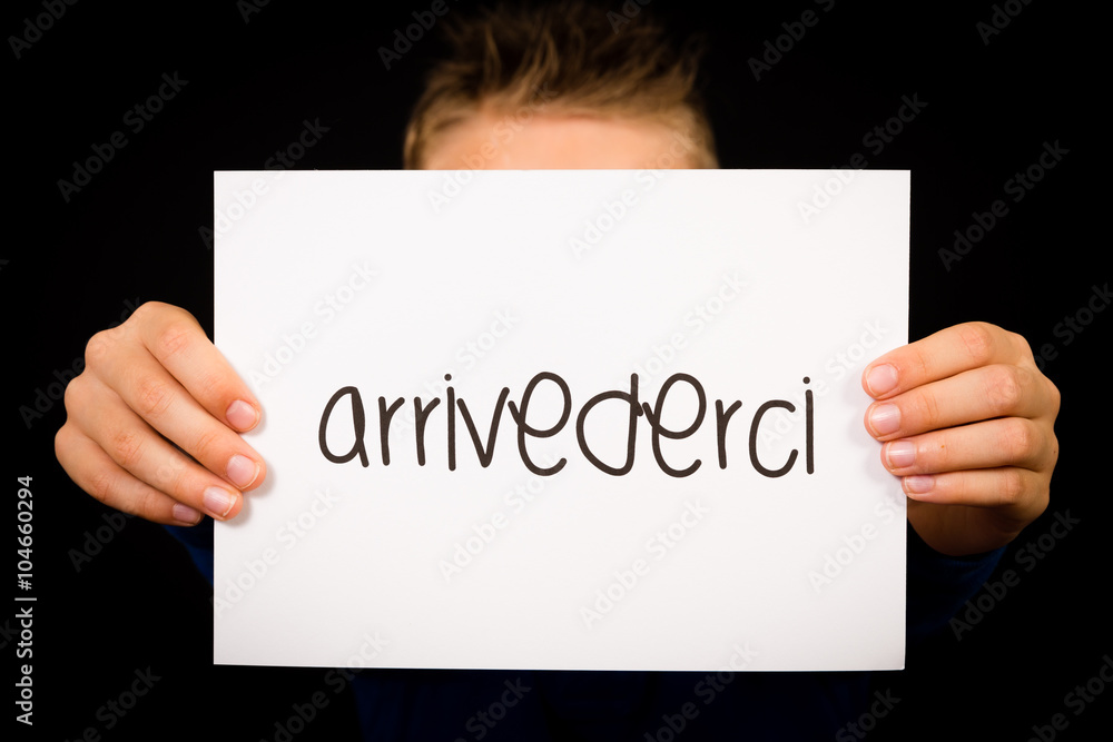 Child holding sign with Italian word Arrivederci - See you later Child holding sign with Italian word Arrivederci - See you later