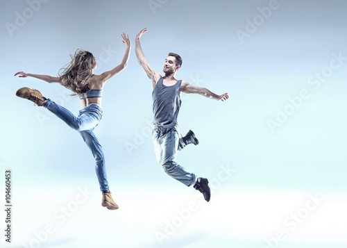 Two young dancers in a jumping pose