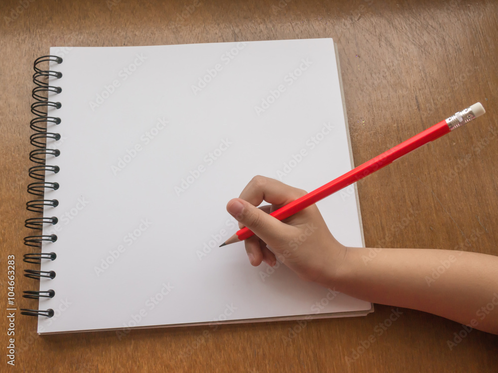 Child catching orange pencil writing on white paper. Child catching orange pencil writing on white paper.