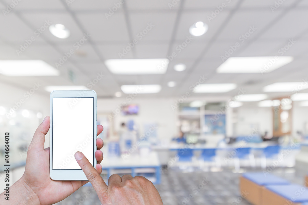 Man using touch screen mobile phone with blurry image of Office Man using touch screen mobile phone with blurry image of Office