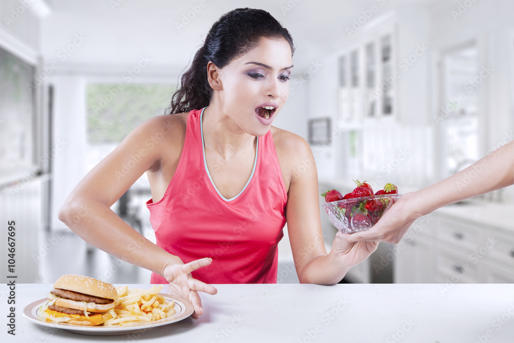 Pretty woman takes strawberry and refuse burger Pretty woman takes strawberry and refuse burger