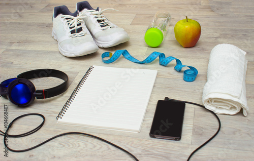 Notebook, smartphone with music, sport equipment and healthy food