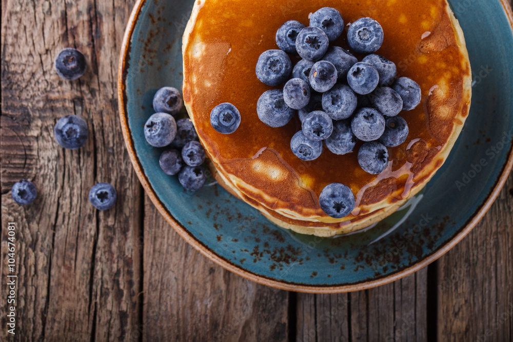 Pancake folded stack of with liquid honey and fresh blueberries on wooden background.selective focus. Pancake folded stack of with liquid honey and fresh blueberries on wooden background.selective focus.