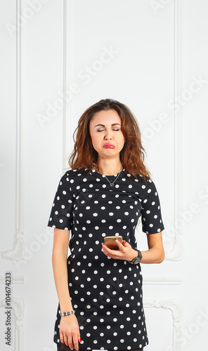 a beautiful young woman holding the phone very upset
