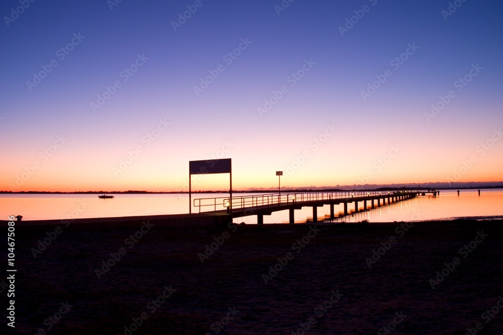 Morning in harbor. Tourists pier above sea. Sunny clear blue sky, smooth water level