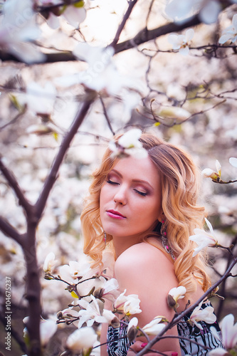 Beauty smiling woman near white magnolia