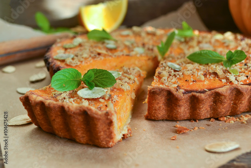 pumpkin tart with cream and cinnamon on rustic background