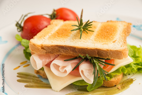 Toasted sandwich with bacon, cheese, tomato and lettuce