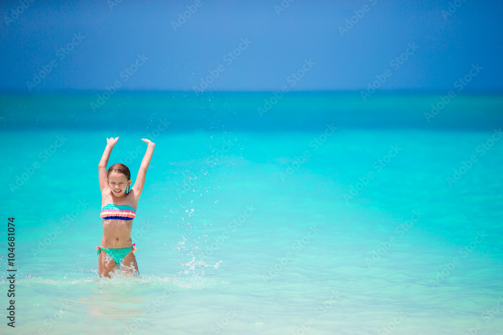 Adorable little girl have fun at shallow water during summer vacation