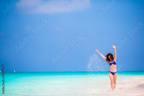 Young woman in swimsuit running and enjoying time at the beach