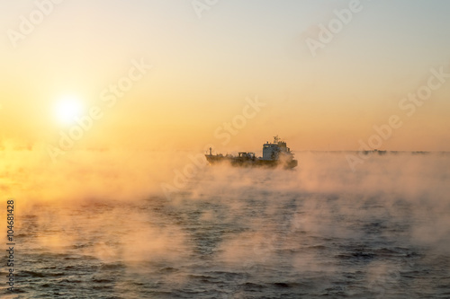  The ship sails at dawn in the fog of the cold winter sea.Estoni © toshket