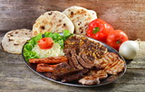 Wholesome platter of mixed meats including grilled steak. Balkan food