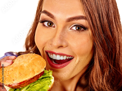 Portrait of happy girl eating big hamburger. Fastfood concept. Isolated.