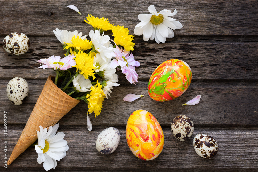 Easter background with eggs and flowers on wooden board, top vie Easter background with eggs and flowers on wooden board, top vie