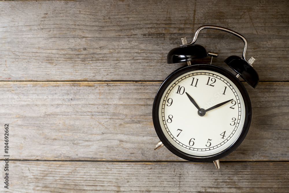 Retro alarm clock on wooden table Retro alarm clock on wooden table