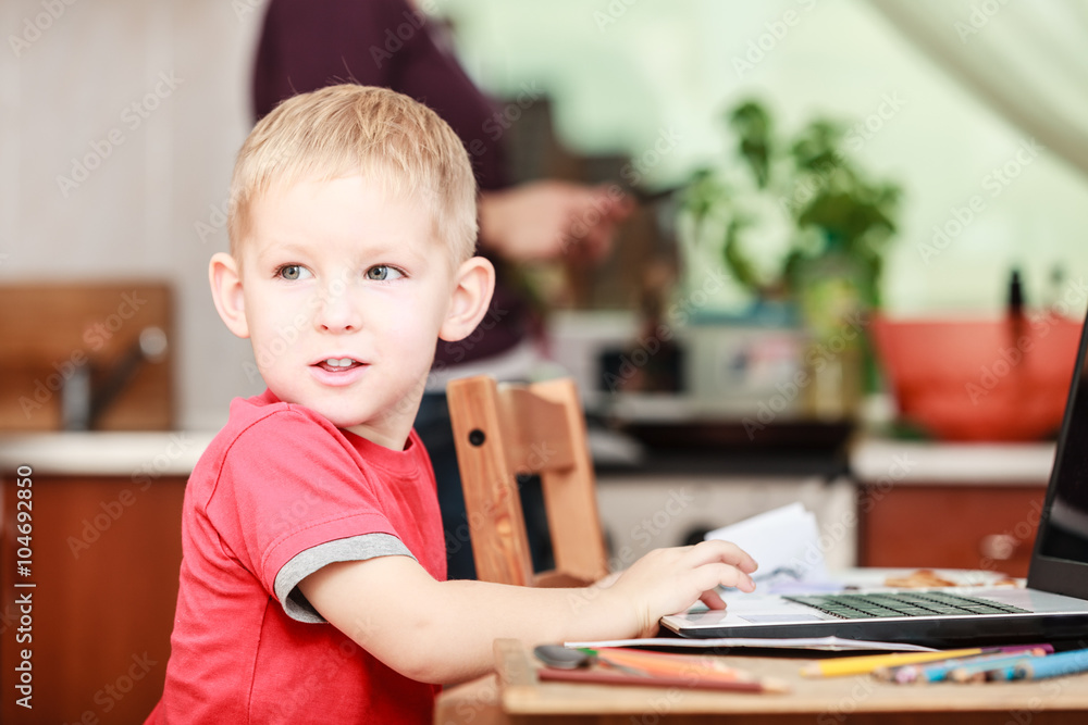 Little boy with laptop on table in home. Little boy with laptop on table in home.