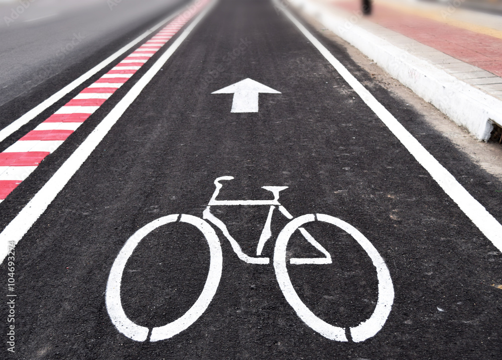 Fototapeta premium White arrow and bycicle sign on lanes road