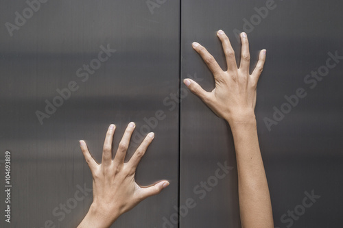 woman hands try to stop doors of the closed elevator