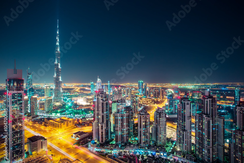Fantastic nighttime Dubai skyline with illuminated skyscrapers. Rooftop perspective of downtown Dubai, UAE.