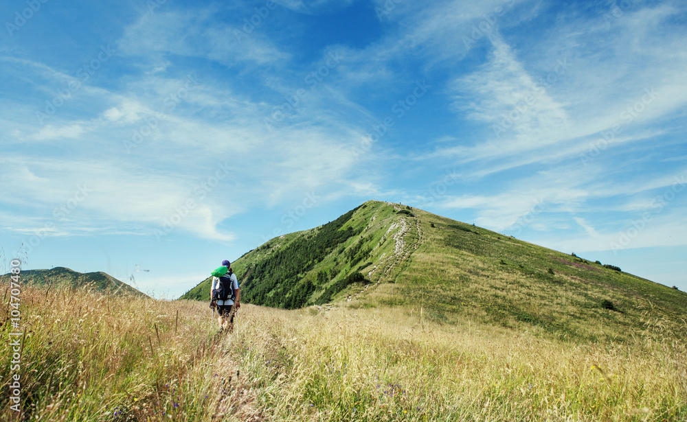 Fototapeta premium Alone hiker walking by the mountain path