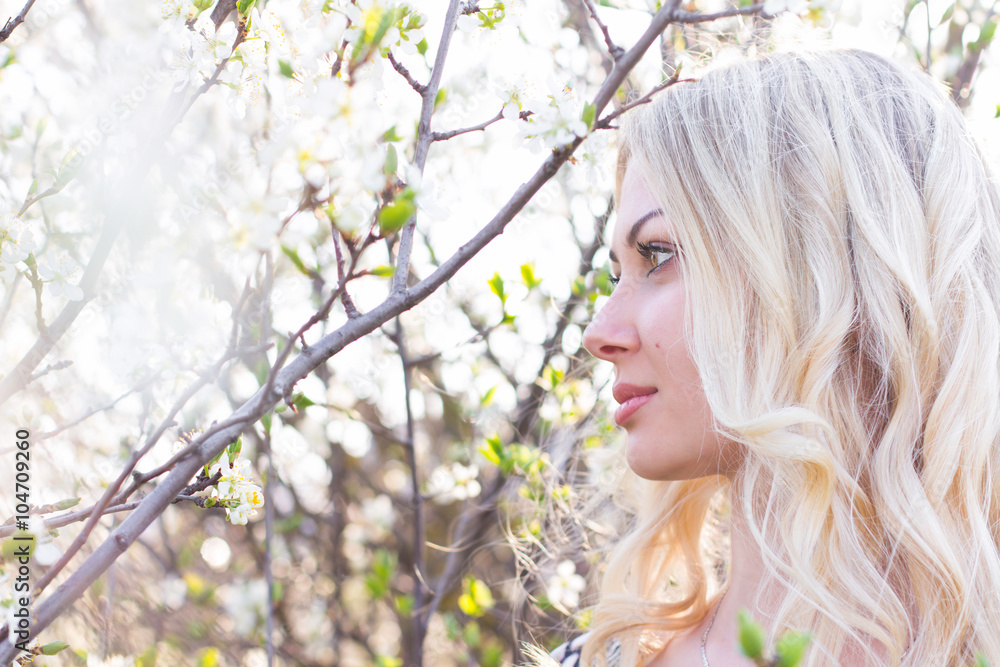 Beautiful blonde girl in spring cherry garden Beautiful blonde girl in spring cherry garden