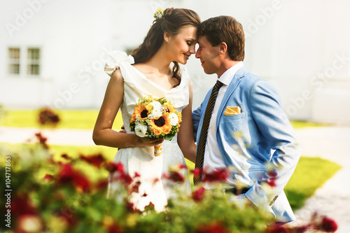 Canvas Print groom in blue suit holding a bride in a white dress in the midst