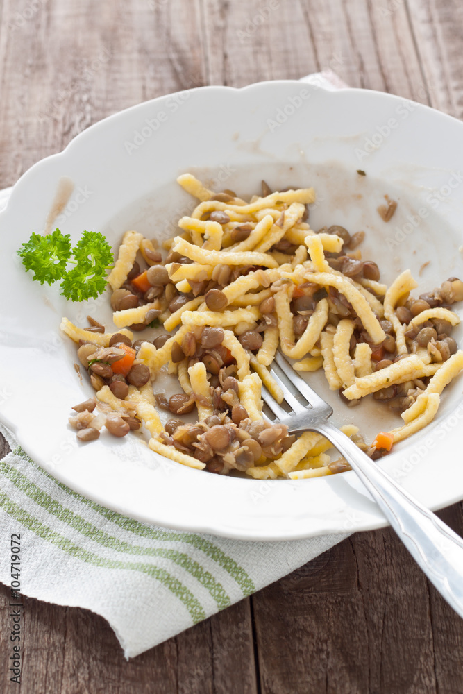Teller mit angegessenen schwäbischen Linsen mit Spätzle Teller mit angegessenen schwäbischen Linsen mit Spätzle