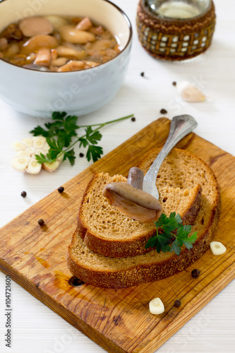 Marinated mushrooms boletus served with bread in rustic style