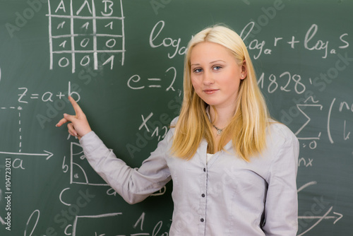 schülerin erklärt mathematikaufgaben an der tafel photo