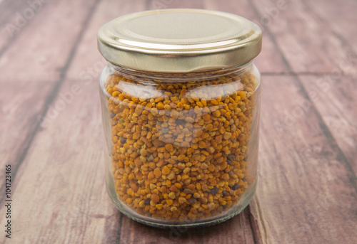 Bee pollen in a mason jar over wooden background