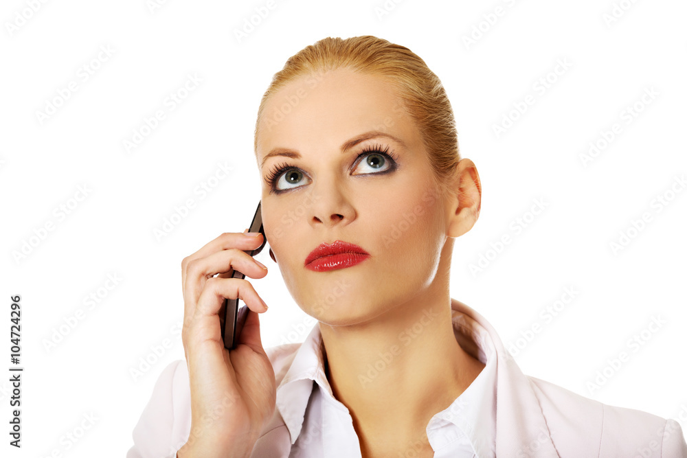 Serious business woman talking through a mobile phone Serious business woman talking through a mobile phone