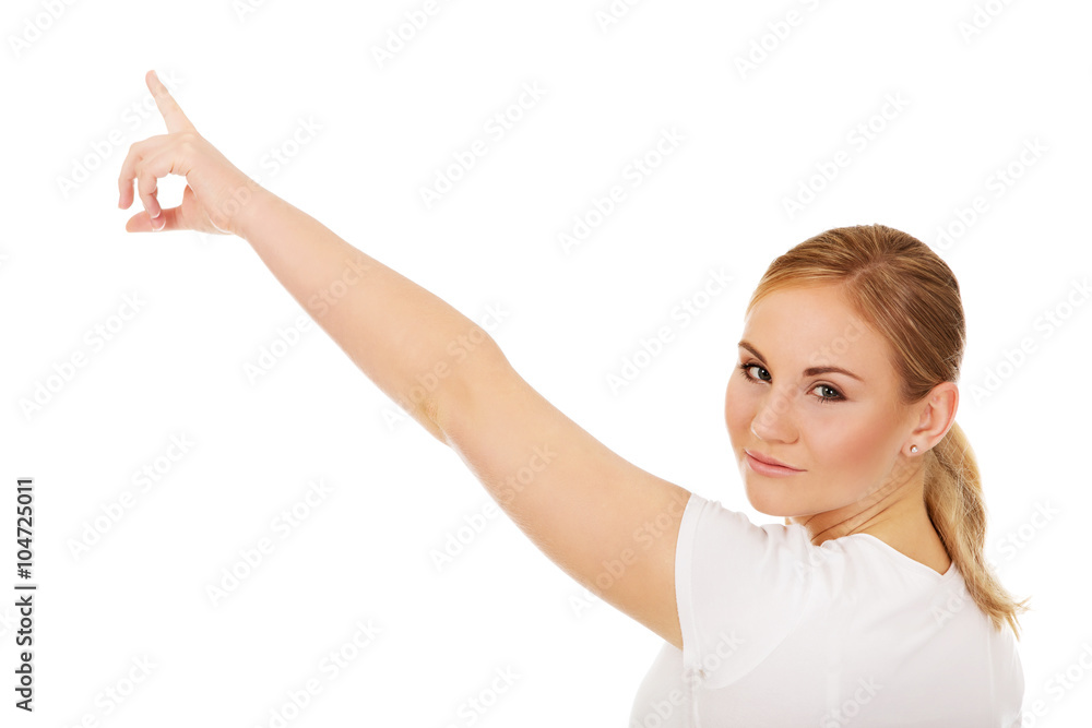Young woman pointing on copy space or something Young woman pointing on copy space or something