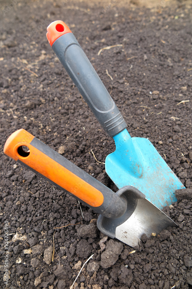 Garden scoops in the loosen soil in the garden Garden scoops in the loosen soil in the garden