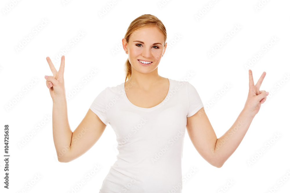 Smiling young woman showing the victory sign Smiling young woman showing the victory sign