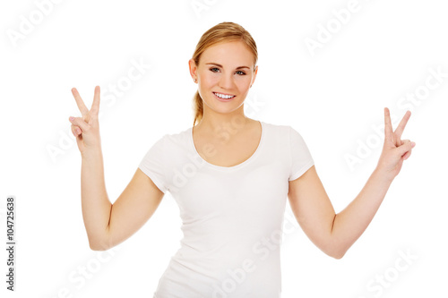 Smiling young woman showing the victory sign
