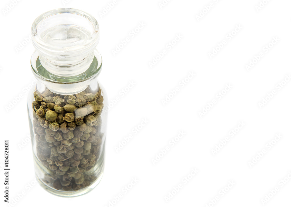 Green peppercorn in glass vial over white background Green peppercorn in glass vial over white background