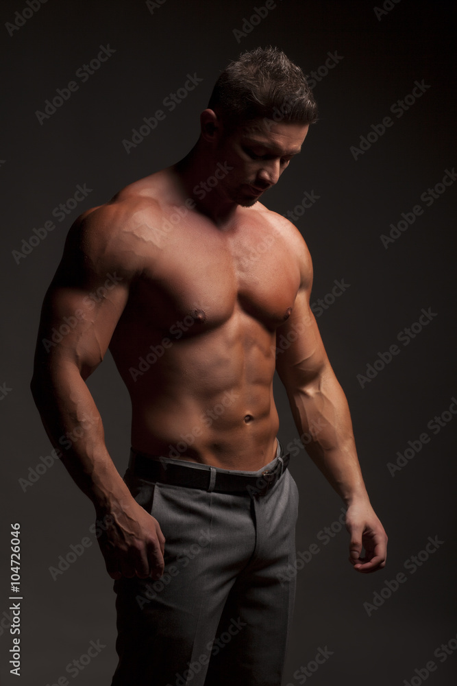 shirtless muscular man in pants posing in studio shirtless muscular man in pants posing in studio