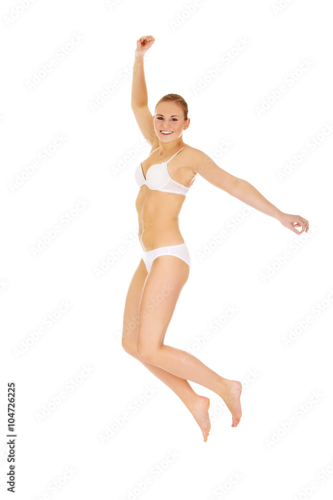 Happy young woman in white underwear jumping Happy young woman in white underwear jumping