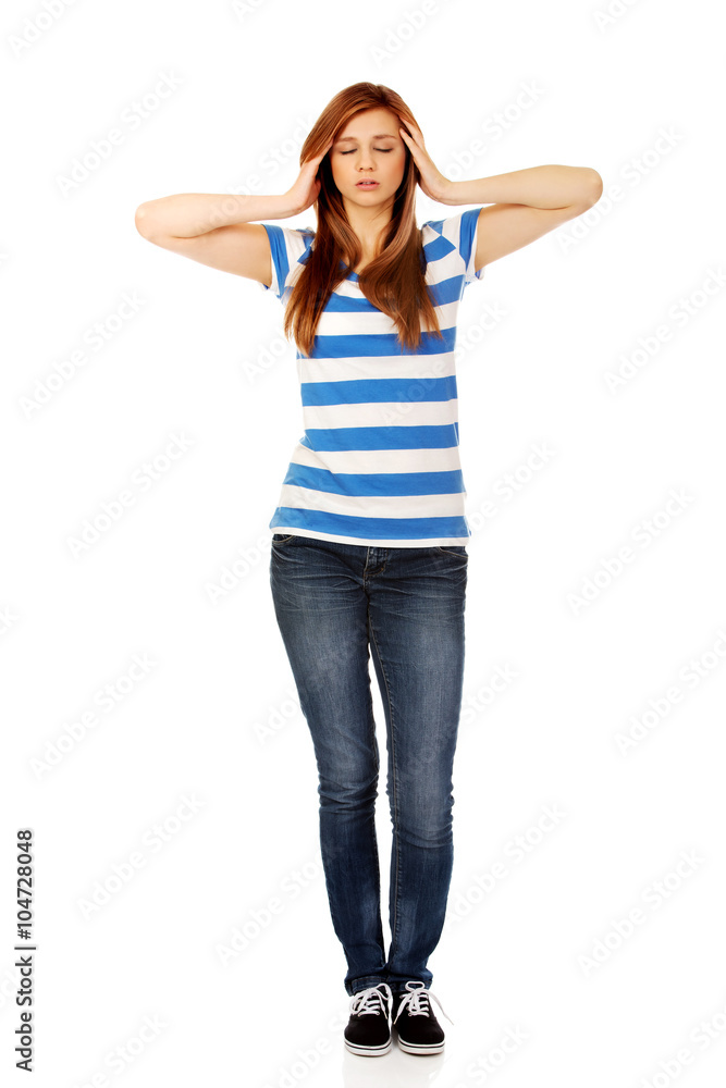 Teenage woman with headache holding her hand to the head