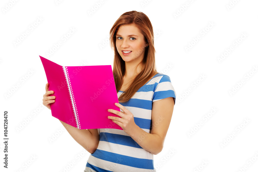 Smiling teenage woman reading her notes Smiling teenage woman reading her notes