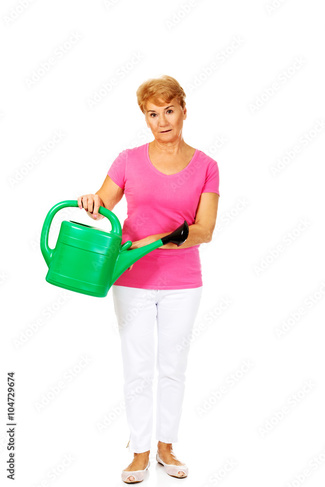 Smiling senior woman with green watering can Smiling senior woman with green watering can