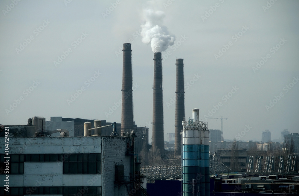 Urban industrial landscape with smoking factory smokestacks 