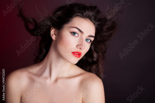 Alyona, serious face with blue contact lenses, red background