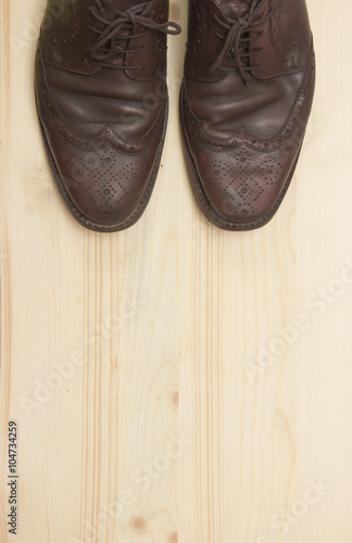 Male brown leather shoes on wooden background, flat lay